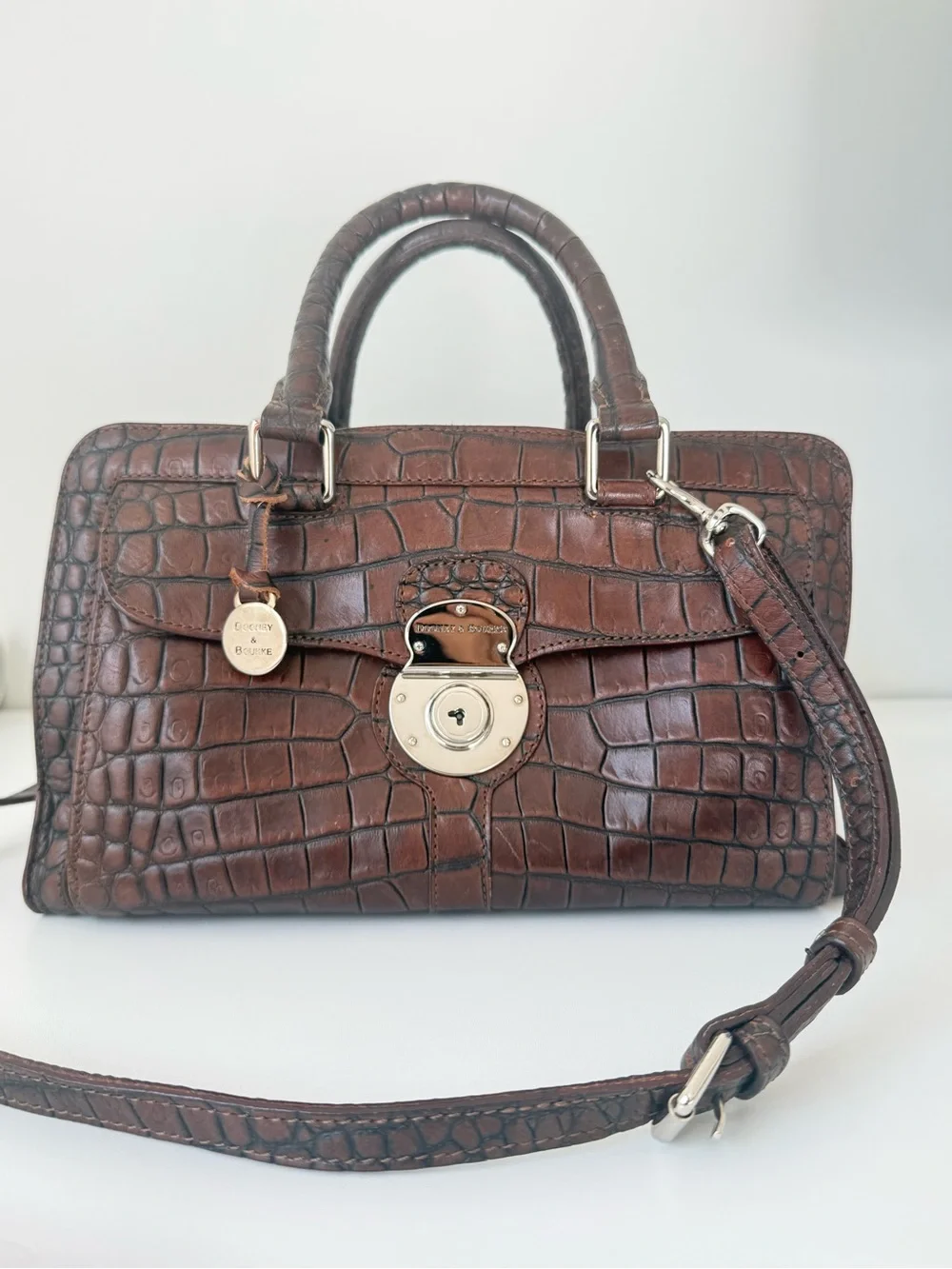 Dooney & Bourke, crafted from rich brown crocodile-embossed leather